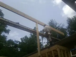Carpenter setting a ridge beam over a new addition frame — Ice Dam Removal by Roofing Brothers in Terryville