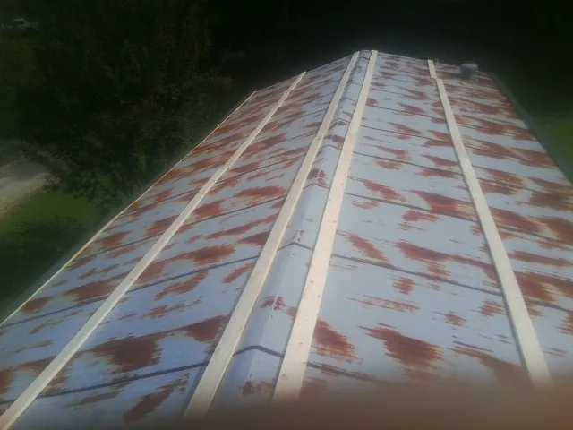 Rusted metal roof panels with new wood purlins before replacement — Storm Damage Roof Repair in Terryville by Roofing Brothers