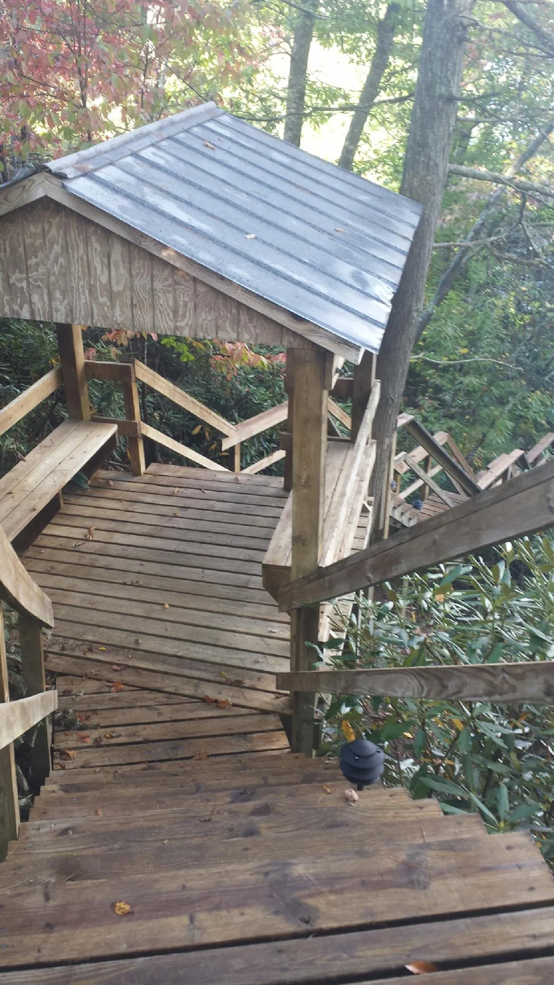 Metal roofed shelter over wooden steps on a wooded walkway — Skylight Repair & Installation work by our crew in Terryville
