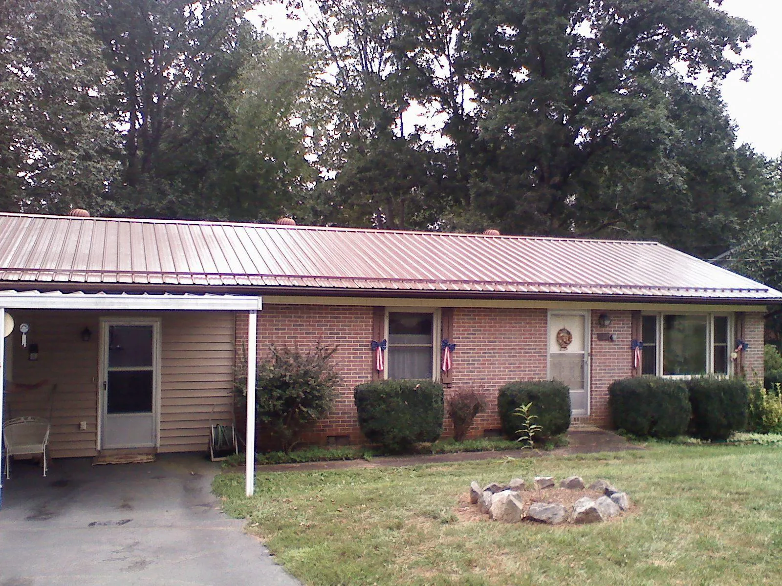 Bronze metal roof and carport on a brick ranch home — Roof Repair work by our crew in Terryville